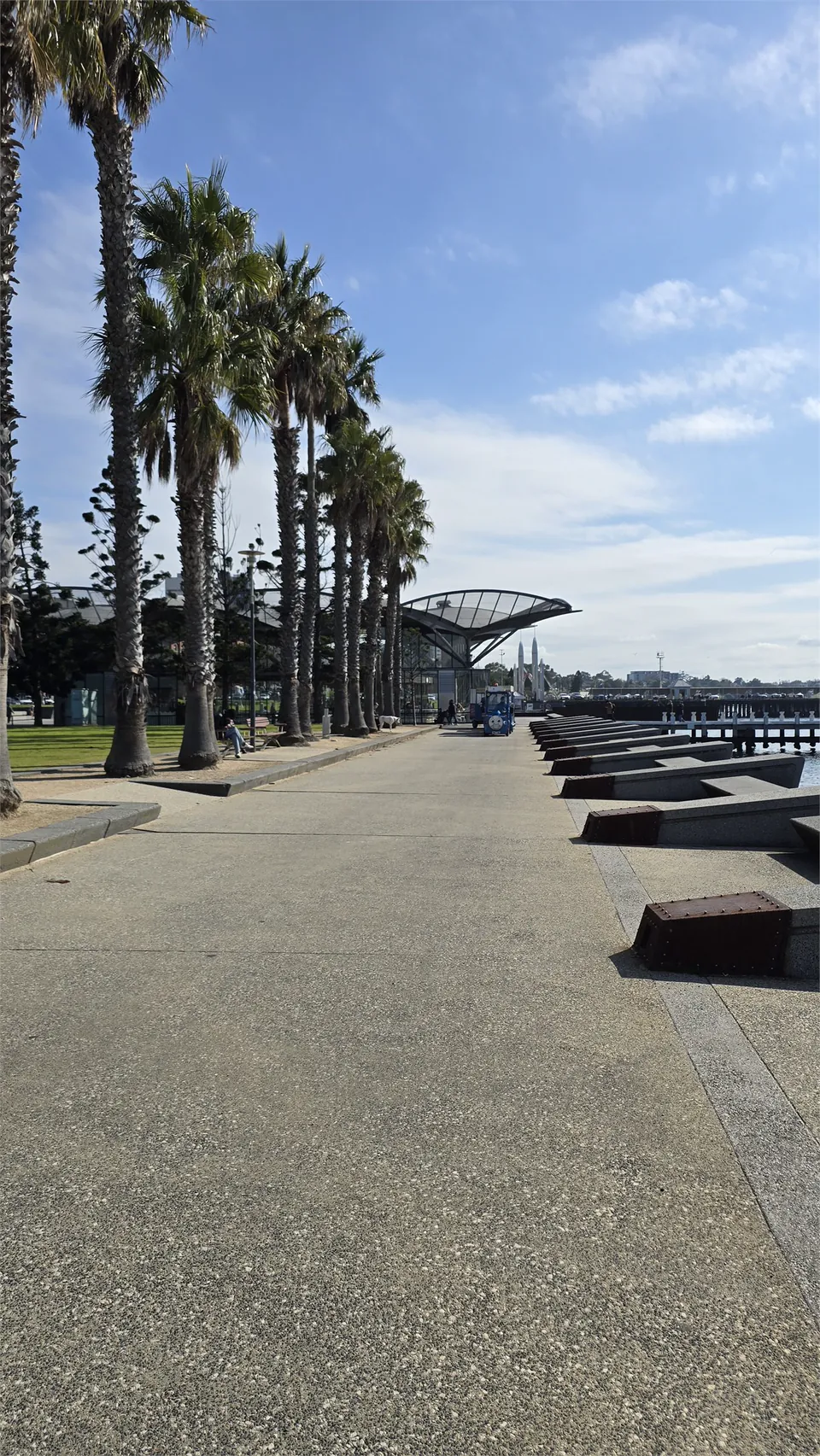 A calm waterfront walkway in soft morning light